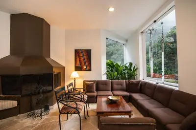 a living room with a couch and a fireplace at Tierra Viva Machu Picchu Hotel in Machu Picchu