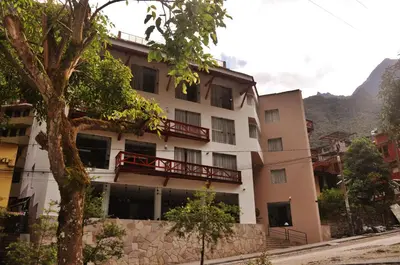 an apartment building with a balcony and a tree at Tierra Viva Machu Picchu Hotel in Machu Picchu