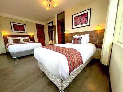 a hotel room with two beds in a room at Hotel Chinchero Boutique & Tours in Chinchero