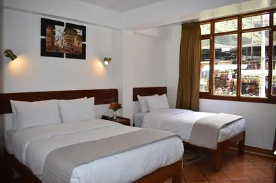 a hotel room with two beds and a window at Casa De Luz Hotel in Machu Picchu