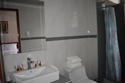 a bathroom with a sink and a toilet and a mirror at Casa De Luz Hotel in Machu Picchu