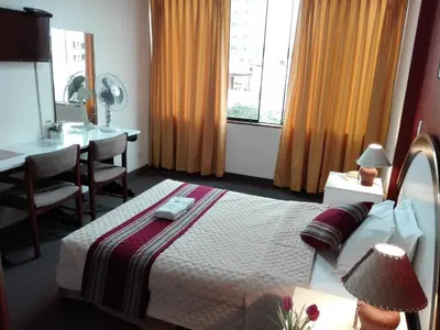 a hotel room with a bed and a table and a window at Los Q'eros in Lima
