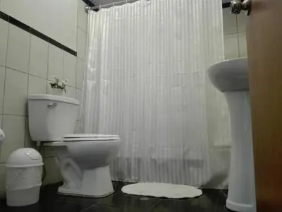 a bathroom with a white shower curtain and a toilet at Los Q'eros in Lima