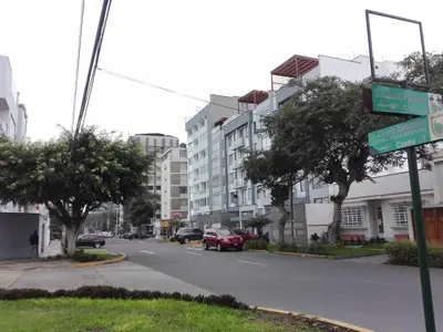 a street sign on a city street with buildings at Los Q'eros in Lima