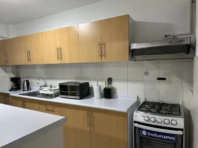 a kitchen with a stove and a microwave at VIVE Apartments Cusco in Cusco