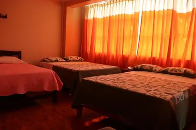 a room with two beds and a window with curtains at Gran Hotel Virrey in San Ramón