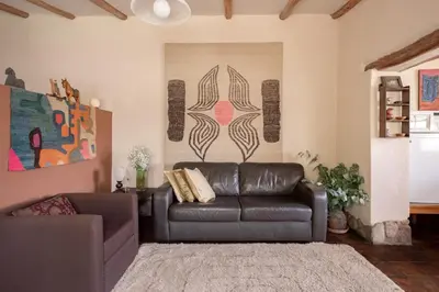 a living room with a leather couch and a rug at Bungalows Perayoc in Urubamba