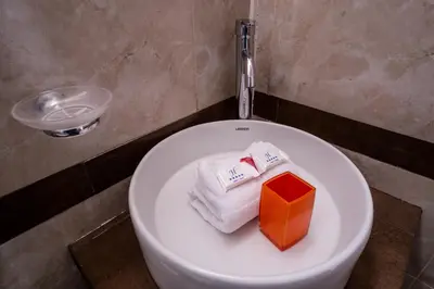 a white toilet with an orange box on it at Askha Cusco in Cusco