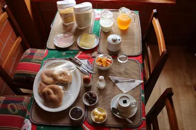 a table with a plate of food on it at Picol Hostal in Cusco