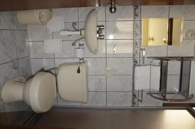 a bathroom with a toilet and a mirror at Picol Hostal in Cusco
