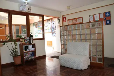a room with a chair and a glass wall at Picol Hostal in Cusco