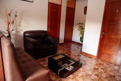 a living room with a leather couch and a coffee table at La Posada D'Benjamín in Oxapampa