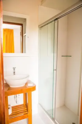 a bathroom with a sink and a glass shower at La Posada D'Benjamín in Oxapampa