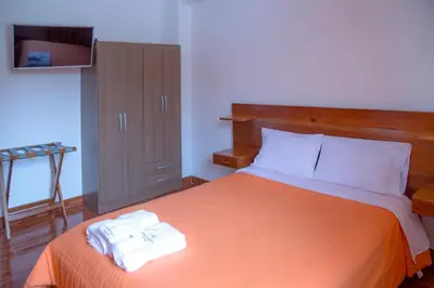 a bedroom with a bed with two towels on it at La Posada D'Benjamín in Oxapampa