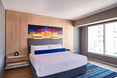 a bedroom with a white bed and a large window at Aloft Lima Miraflores in Lima