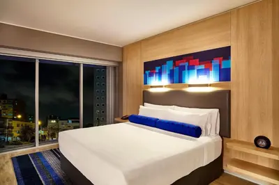 a bedroom with a large white bed and a window at Aloft Lima Miraflores in Lima