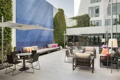 a patio with chairs and tables in a building at Aloft Lima Miraflores in Lima