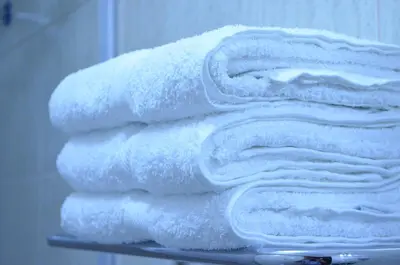 a stack of towels on a shelf in a bathroom at Viandina Machupicchu in Machu Picchu
