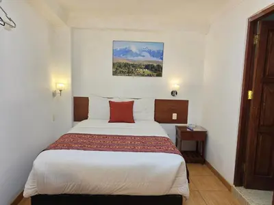 a hotel room with a bed with a red pillow at Viandina Machupicchu in Machu Picchu