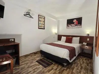 a hotel room with a bed and a desk at Viandina Machupicchu in Machu Picchu