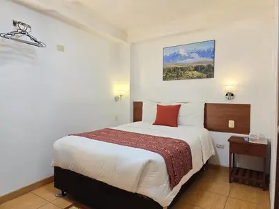 a hotel room with a large bed with red pillows at Viandina Machupicchu in Machu Picchu