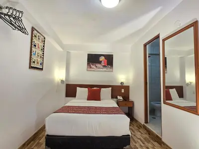 a hotel room with a bed and a bathroom at Viandina Machupicchu in Machu Picchu