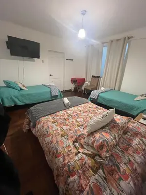 a hotel room with two beds and a flat screen tv at Uli´s house in Lima