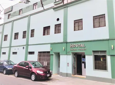 two cars parked in front of a building at Hostal Carlos Tenaud in Lima