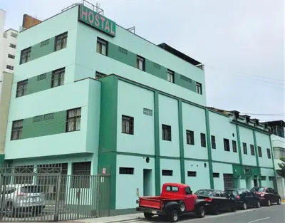 a red truck parked in front of a building at Hostal Carlos Tenaud in Lima