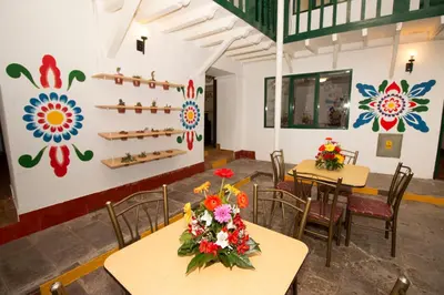 a room with two tables and chairs with flowers on them at Cusco Plaza Nazarenas in Cusco
