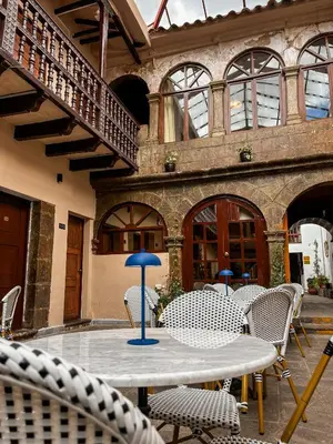 a table with chairs and blue lamps on a patio at Hotel Cusco Plaza Saphi in Cusco