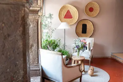 a living room with a chair and a table with flowers at Hotel Cusco Plaza Saphi in Cusco