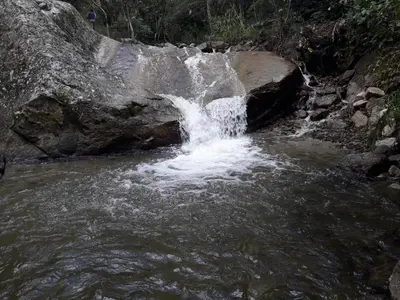 a small waterfall in a river with rocks at Eco Hacienda Roman in Machu Picchu