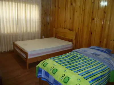 a bedroom with two beds in a wooden room at HOSPEDAJE CAMPOS ELÌSEOS in Oxapampa