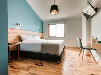 a bedroom with a bed and a desk and a chair at Muru Homely Hotel Cusco in Cusco