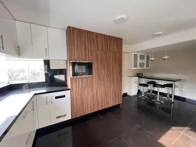 a kitchen with white cabinets and a counter with stools at El Golf los inkas luxury Penthouse in Lima