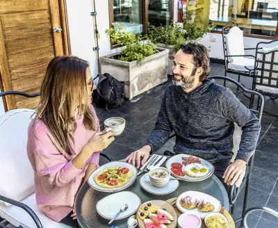 a man and woman sitting at a table eating food at Tariq Boutique in Cusco