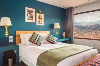 a bedroom with a large bed with a blue wall at Tariq Boutique in Cusco