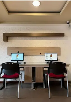 two computers sitting on a desk with two chairs at Hotel El Marqués in Lima
