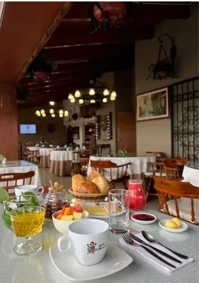 a table with cups and plates of food on it at Hotel El Marqués in Lima