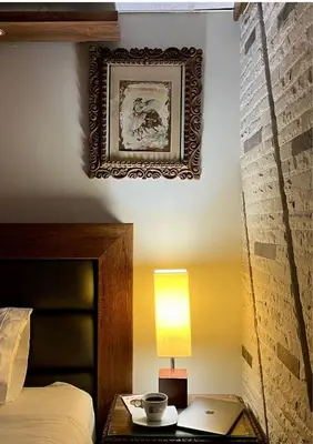 a bedroom with a bed and a table with a lamp at Hotel El Marqués in Lima