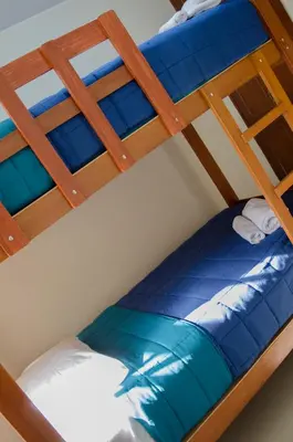 two bunk beds with blue and white pillows on them at Jazmines Lodging in Ica