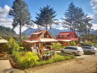 a group of people standing in front of a house at HASSINGER RANCH Cabañas in Oxapampa