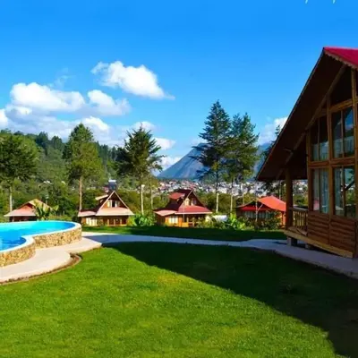a resort yard with a pool and a building at HASSINGER RANCH Cabañas in Oxapampa