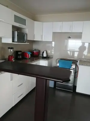 a kitchen with white cabinets and a counter top at Beachfront Condo San Miguel in Lima