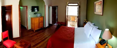 a bedroom with a red bed and green walls at Centro Vacacional Huaychulo in Concepción