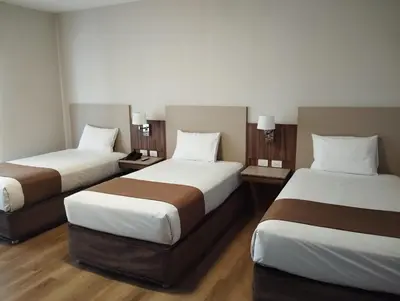 a hotel room with two beds and two lamps at DM Hoteles Ayacucho in Ayacucho