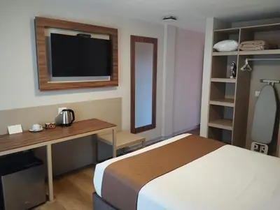 a bedroom with a bed and a desk and a television at DM Hoteles Ayacucho in Ayacucho