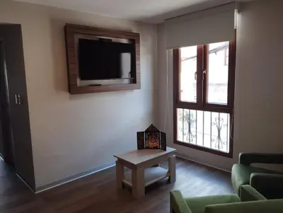 a living room with a tv and a couch and a table at DM Hoteles Ayacucho in Ayacucho