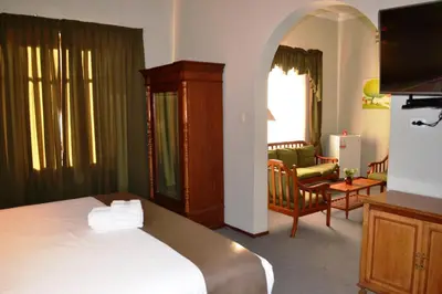 a bedroom with a bed and a living room at DM Hoteles Mossone - Ica in Ica